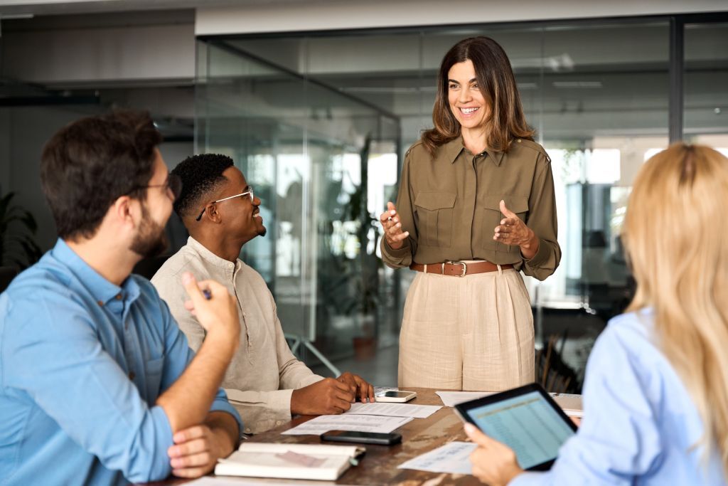 A group of employees around a table watching a presentation.