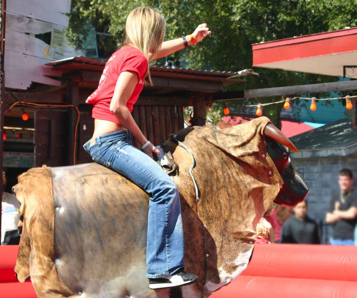 A woman riding a mechanical bull 