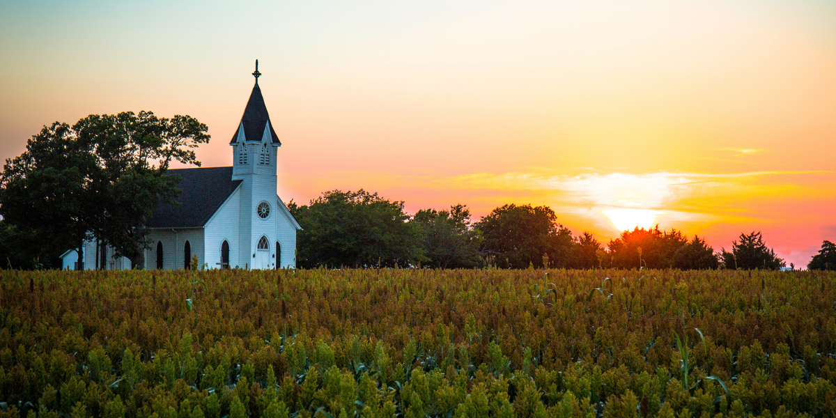 Church in corn field at sunset