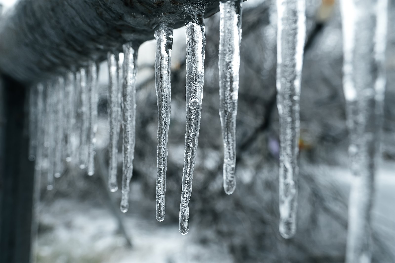 Small icicles hang from a structure in winter.