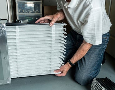 Man replacing furnace air filter