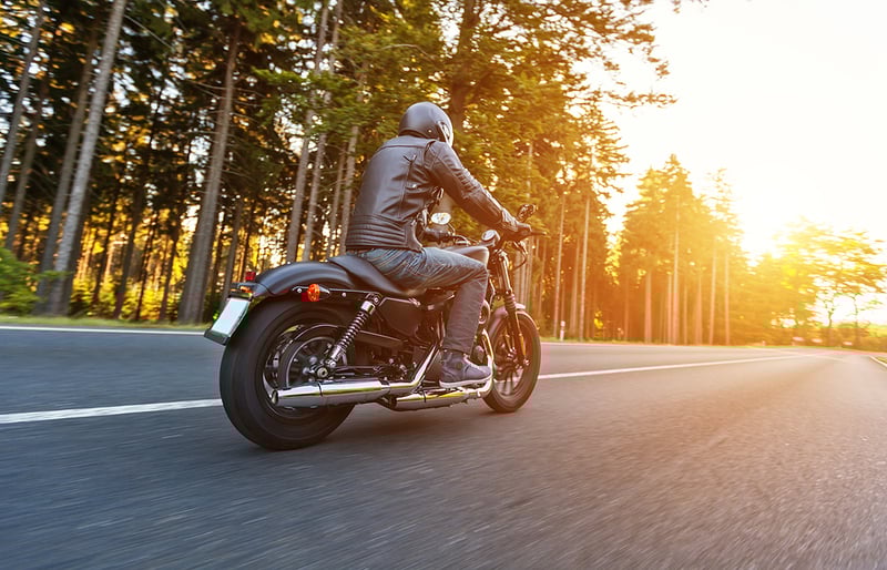 Motorcyclist rides into sunset