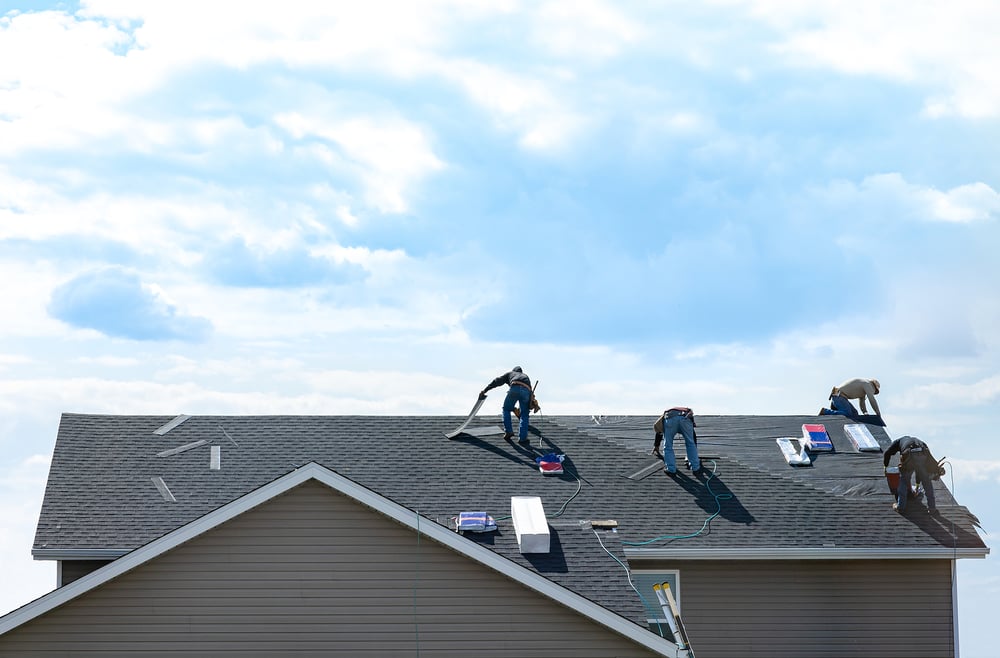 Workers replacing a home's roof