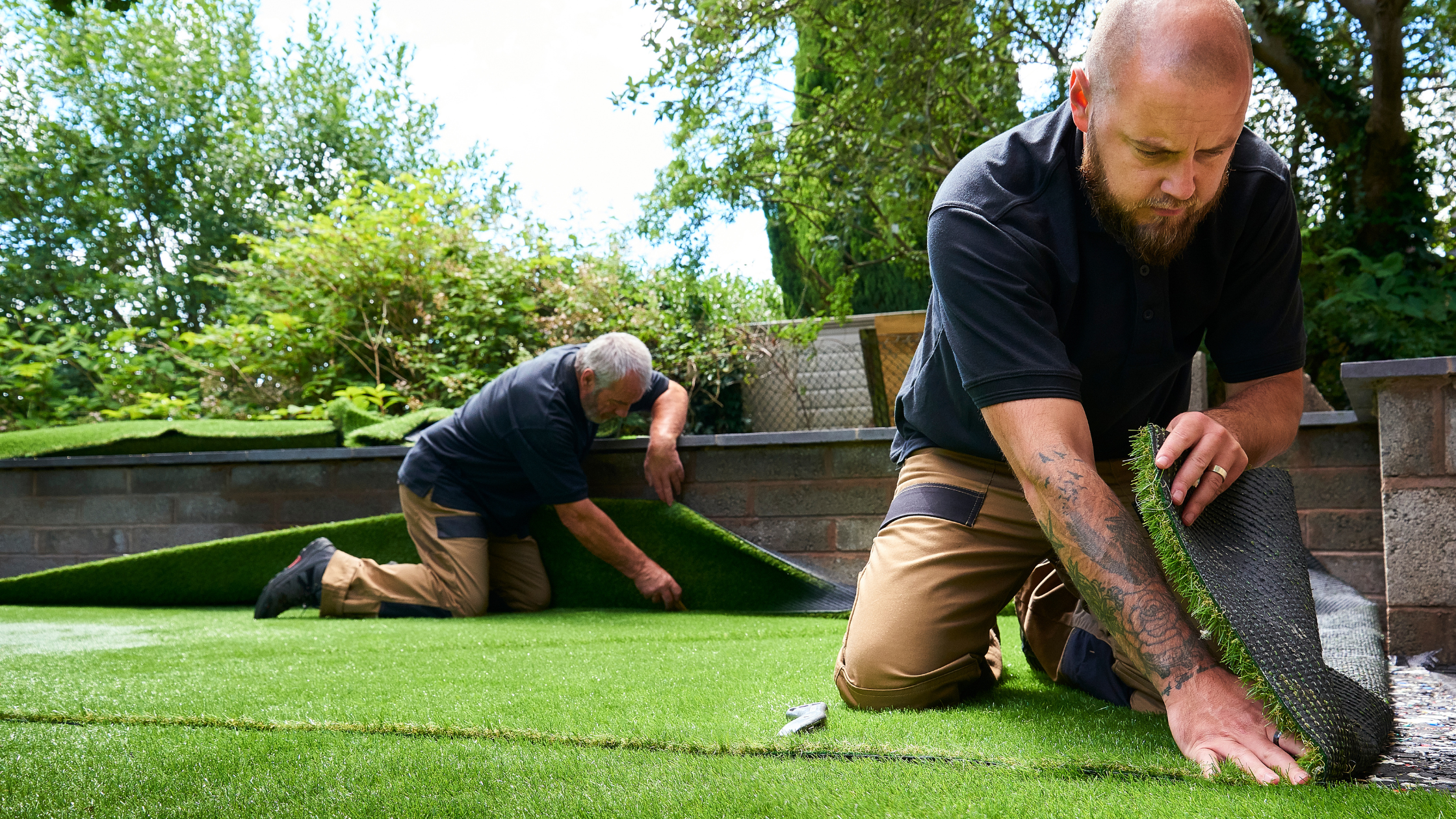 two men laying grass down