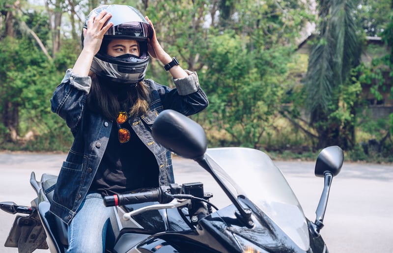 Woman puts on motorcycle helmet