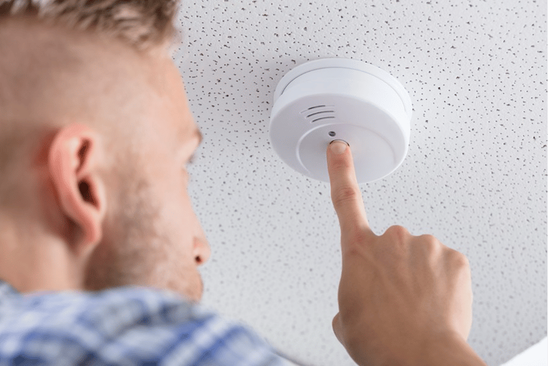 man checking a smoke detector