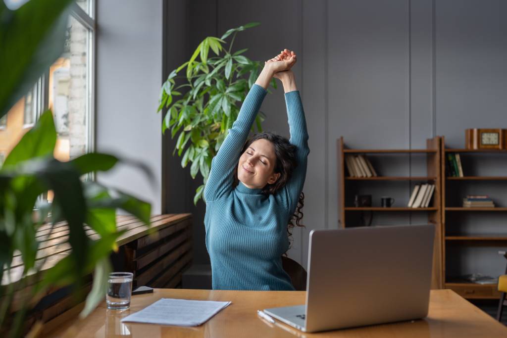 Happy employee stretching at desk