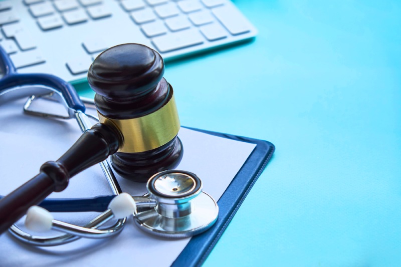 Gavel and stethoscope sitting on desk near keyboard