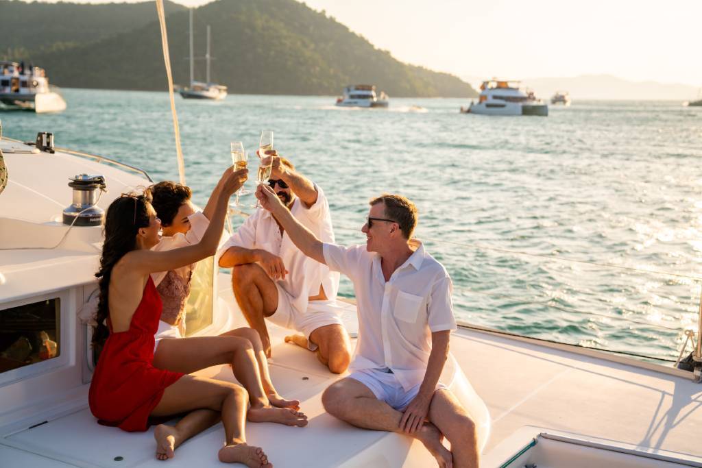 Two couples drinking wine on a yacht.