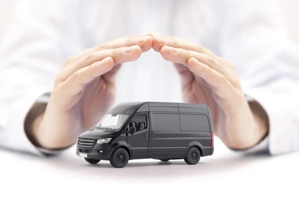 Hands shielding miniature commercial vehicle from damage