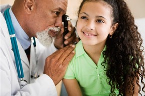 Doctor checking little girl's ear