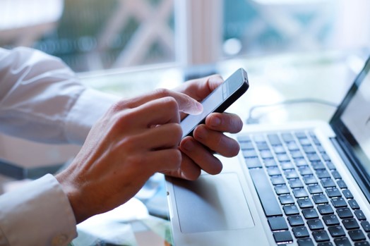 person on phone and computer