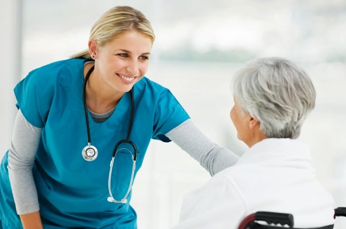 nurse smiling at patient in wheelchair